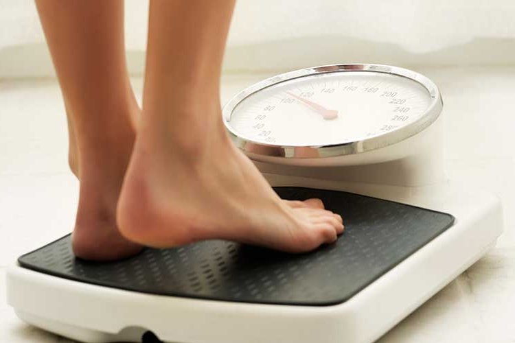 Frau steht auf Waage